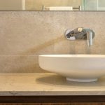 A photo of a wall-mounted mixer tap in a bathroom sink.