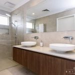 A photo of a bathroom, with a shower, sink and large mirror.