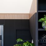 A photo of cabinets in a kitchen, a plant and a fridge