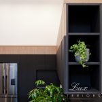 A photo of kitchen cabinets with a plant in it.