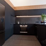 A photo of a kitchen with an oven, a fridge and a plant.