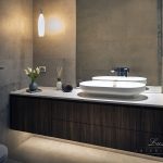 A photo of a bathroom sink over a cabinet with a plant on the side. A towel rack on the wall.