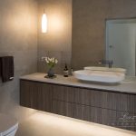 A photo of a bathroom with a toilet, a sink and a towel rack.