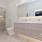 A photo of a bathroom area with a large shower in the background.