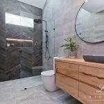 A photo of a bathroom area, with a glass shower in the background.