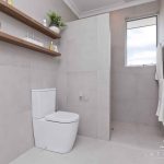 A photo of a bathroom area, with a toilet and shower in the background.