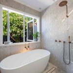 A photo of a bathroom area, with a bath tub and shower.