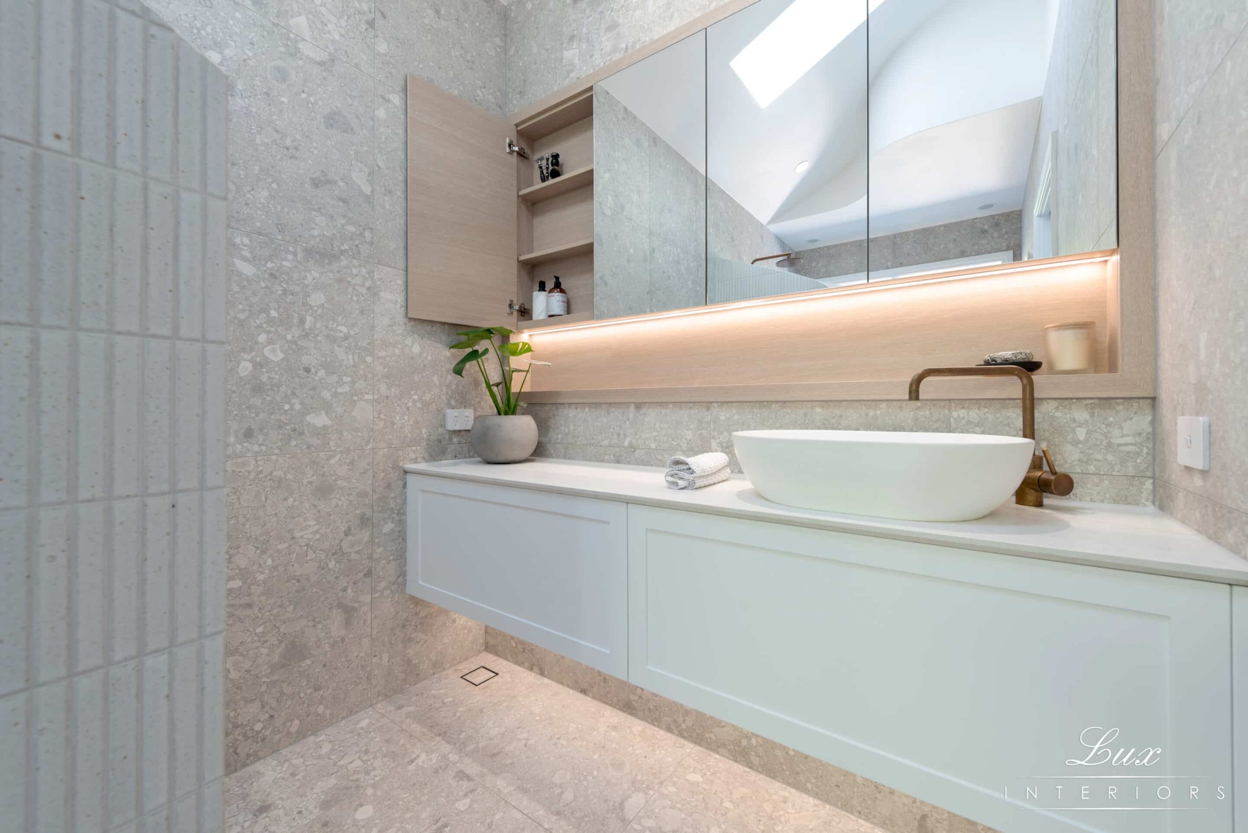 A photo of a bathroom sink and large mirror.