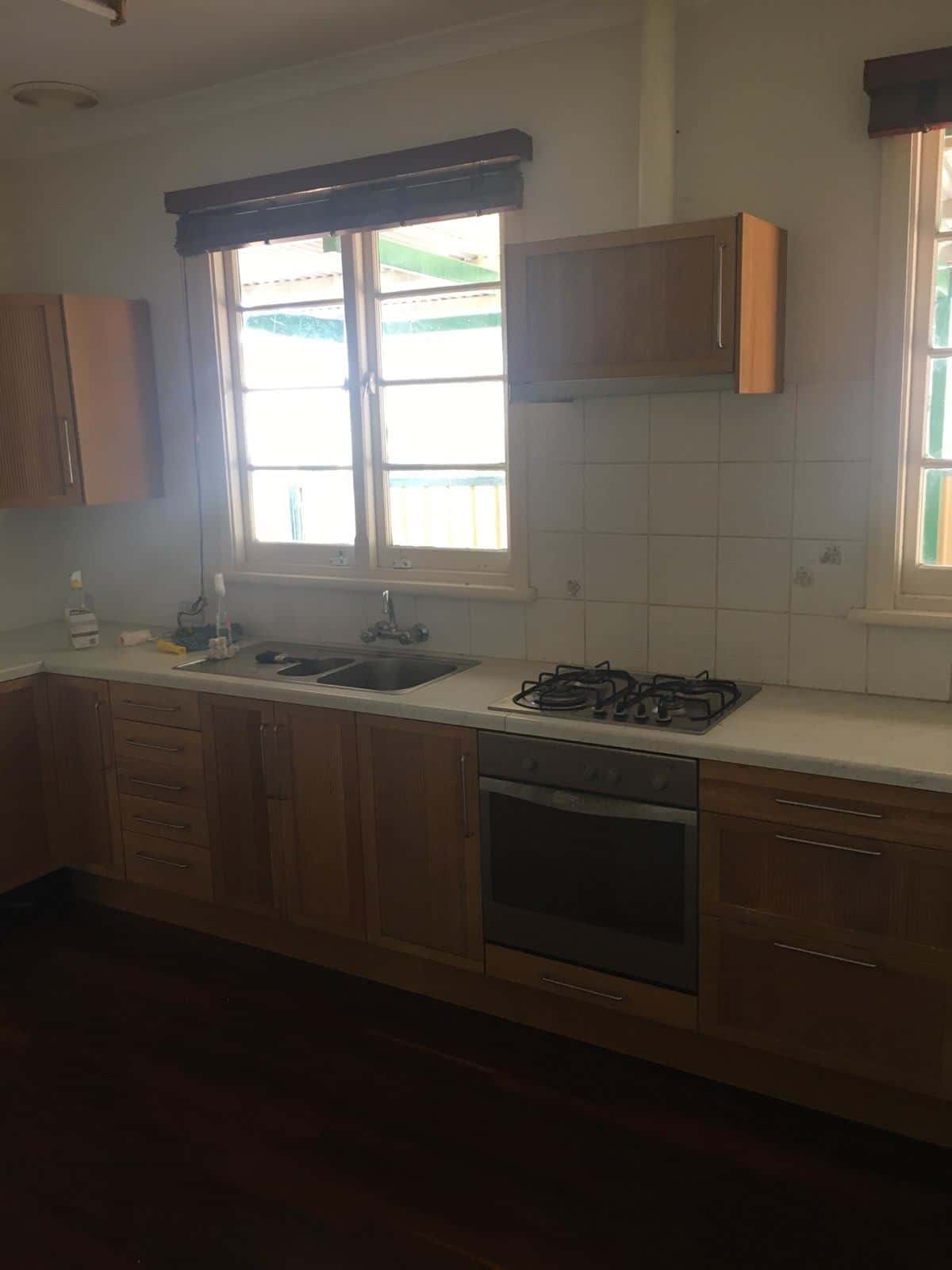 A photo of a kitchen area, old and slightly dirty, before being renovated.