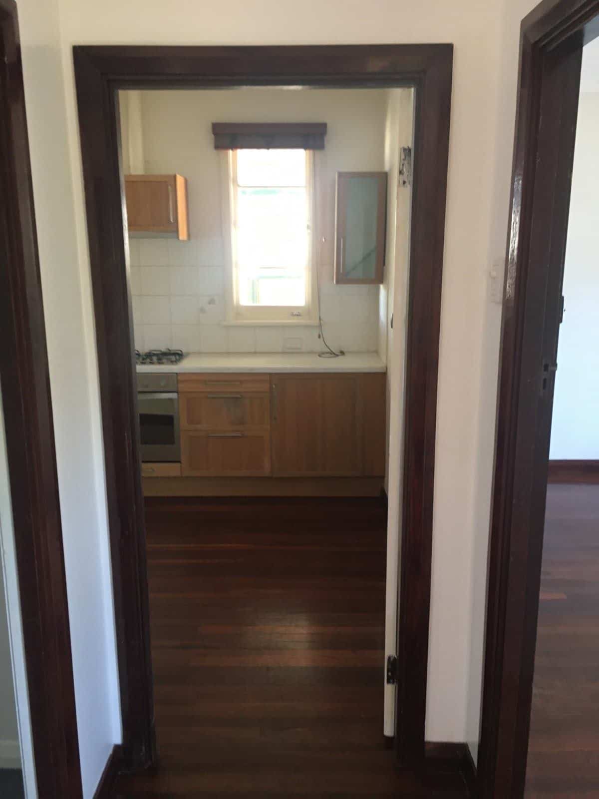 A photo of a kitchen, through a door frame.