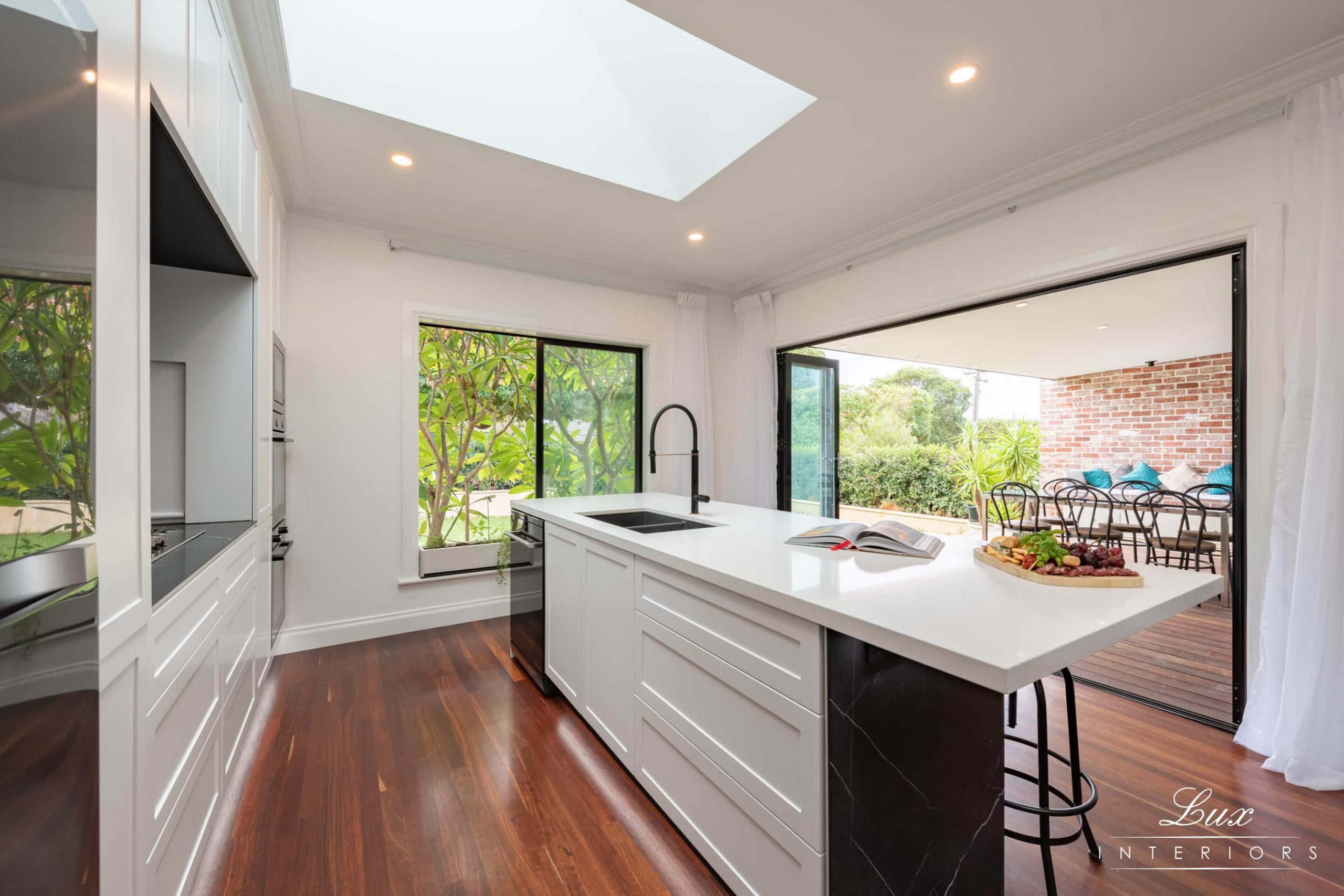 A photo of a kitchen area, with a centre island and sink, dishwasher in the background.