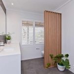 A photo of a bathroom area, with dual sinks and a toilet in the background.