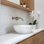 A photo of a sink, with a large bowl for the basin and a curved tap.