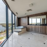 A photo of an ensuite bathroom, with a large bath tub, with views of the swan river in the background.