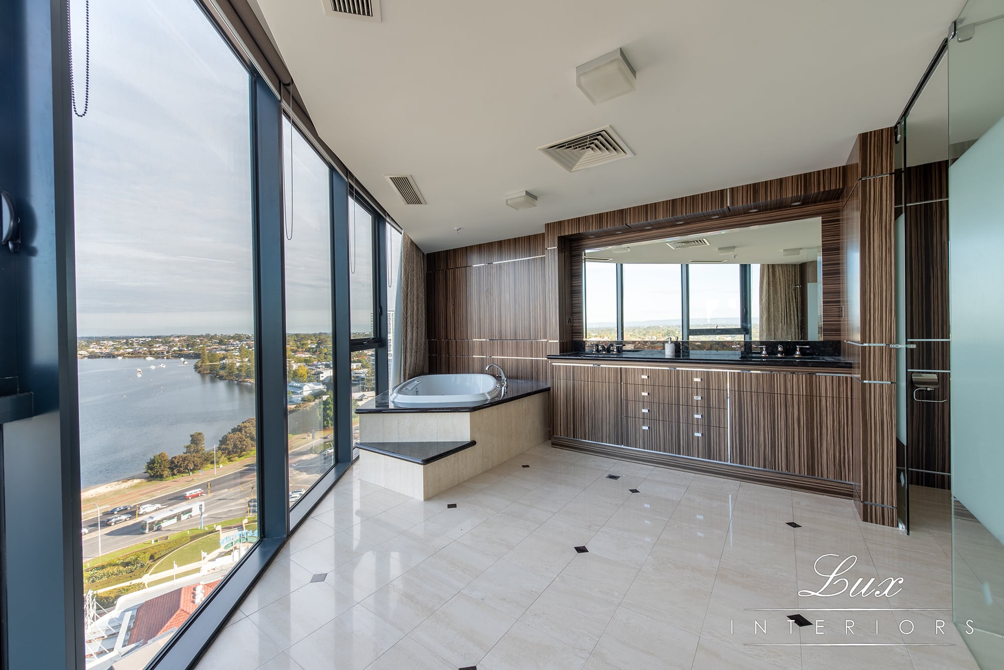 A photo of an ensuite bathroom, with a large bath tub, with views of the swan river in the background.