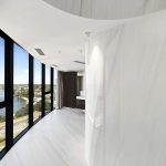 A photo of a white marble corridor, with swan river views in the background.