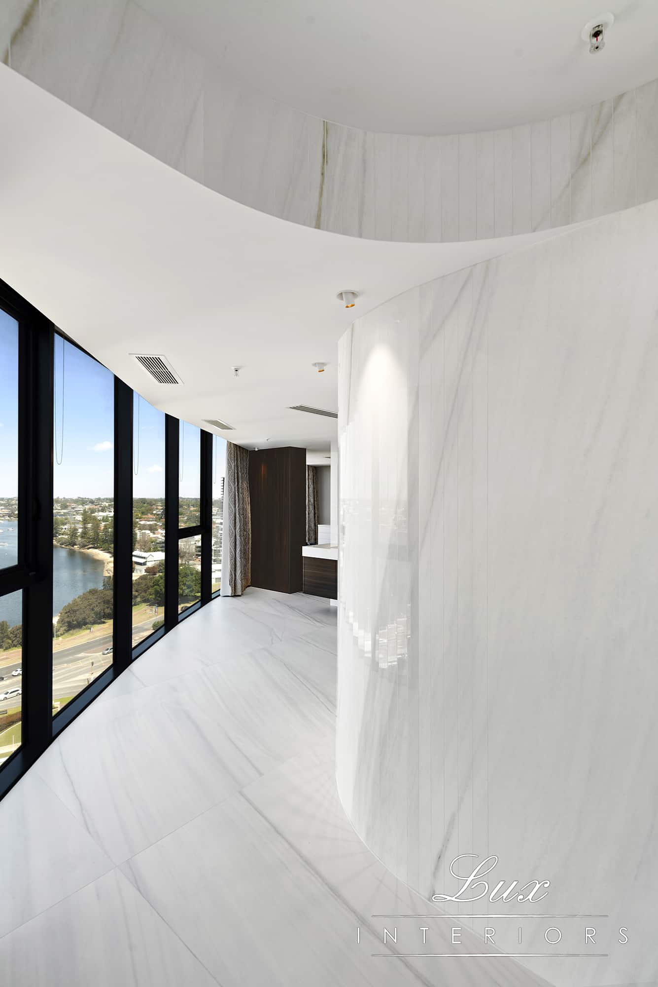 A photo of a white marble corridor, with swan river views in the background.