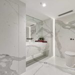 A photo of a bathroom area, with large mirrors and a toilet.