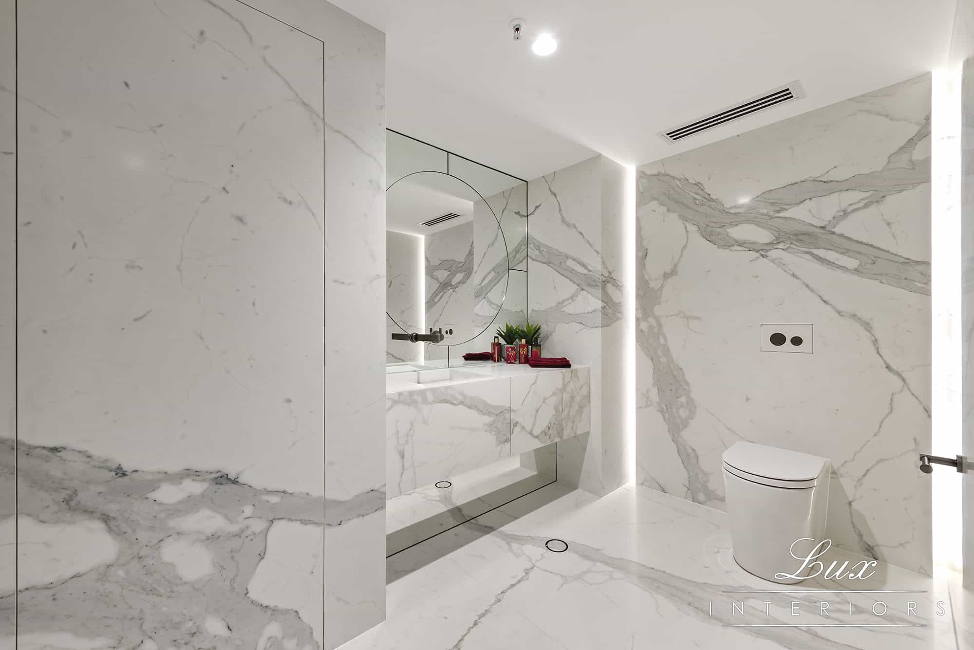 A photo of a bathroom area, with large mirrors and a toilet.