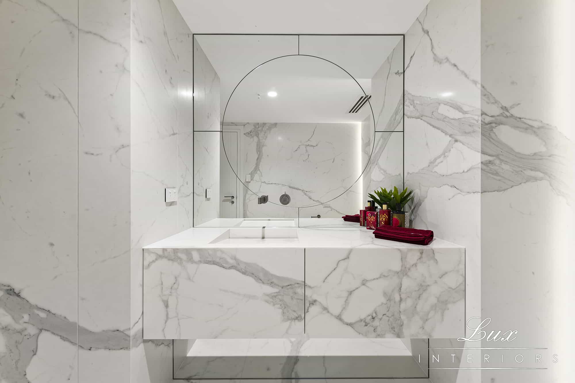 A photo of a sink, with a large mirror.