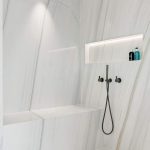 A photo of a shower area, with a ledge to sit down on whilst showering.