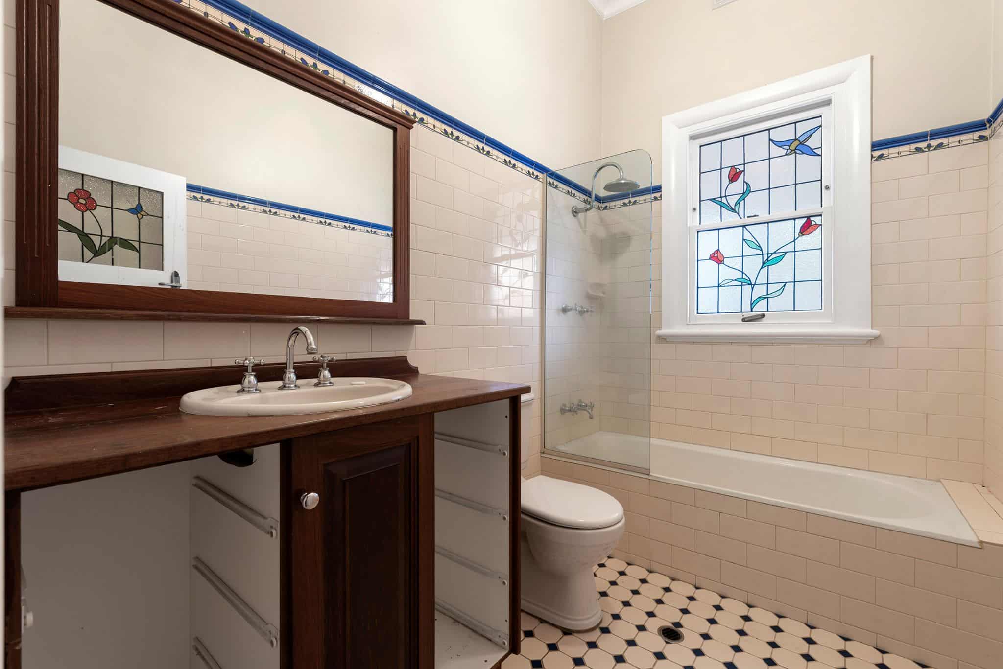 A photo of a bathroom area, with bath and shower in the background.