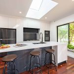 A bright, light-filled kitchen with white countertops.