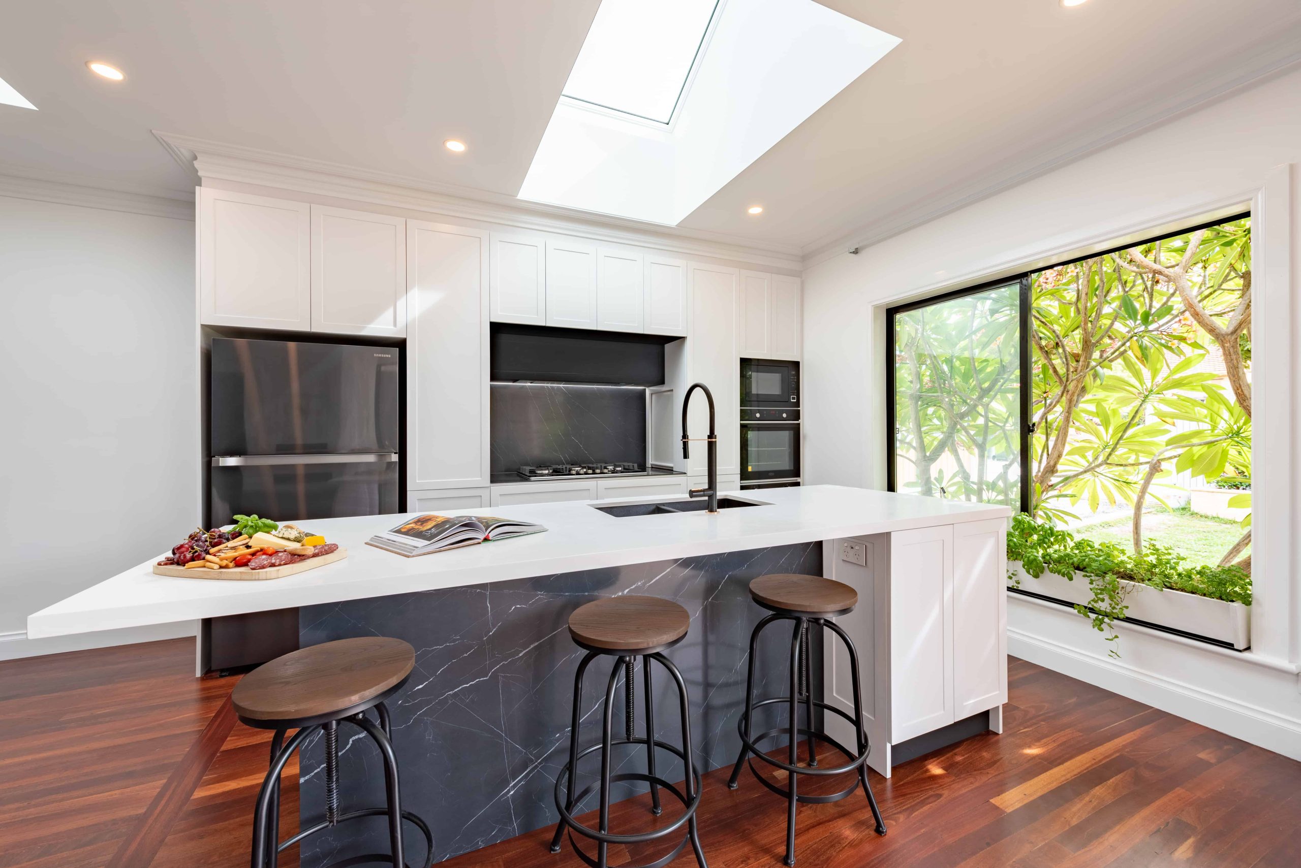 A bright, light-filled kitchen with white countertops.