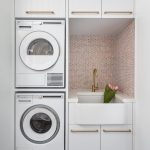 A photo of a laundry area, with a sink, washing machine and dryer.