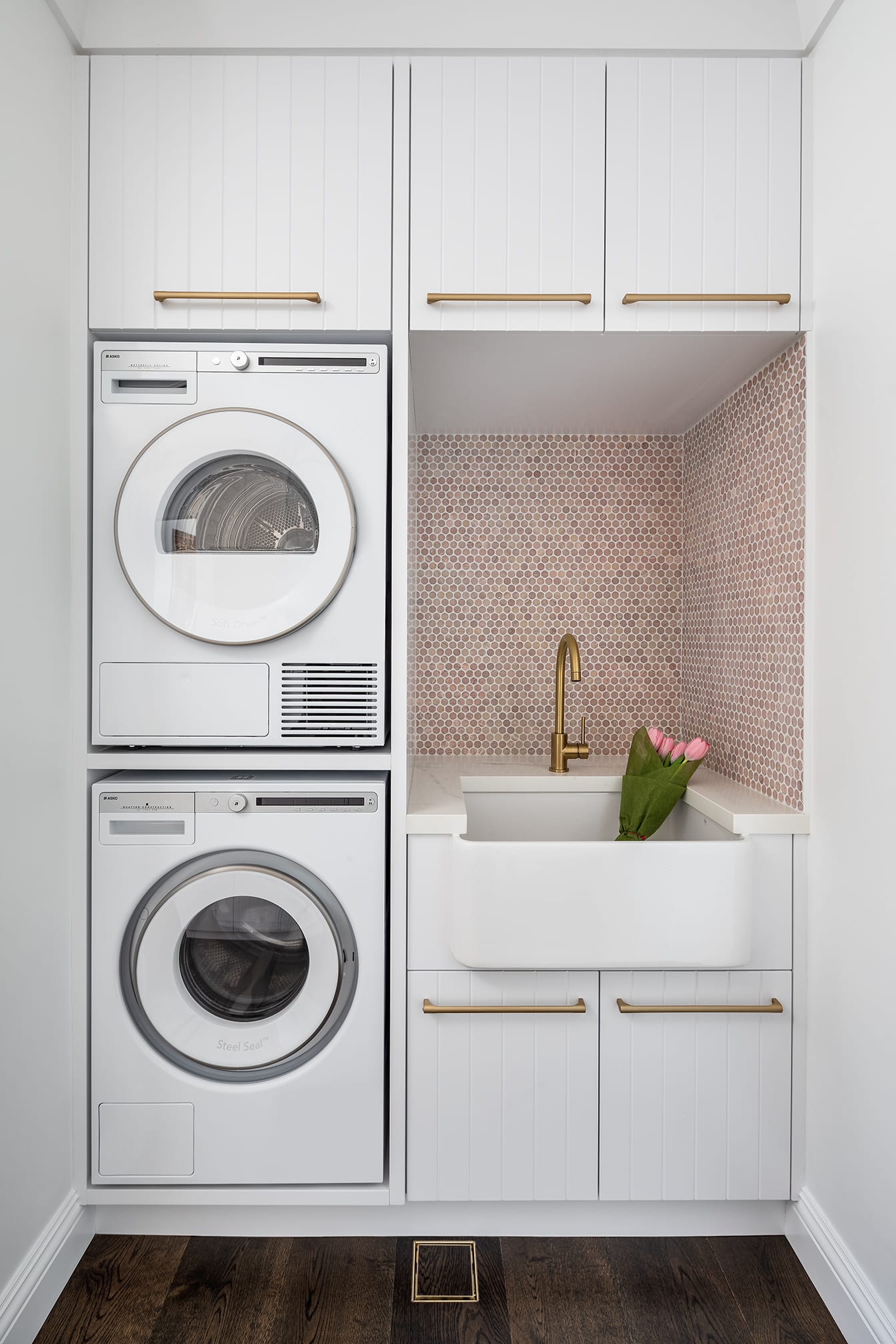 A photo of a laundry area, with a sink, washing machine and dryer.