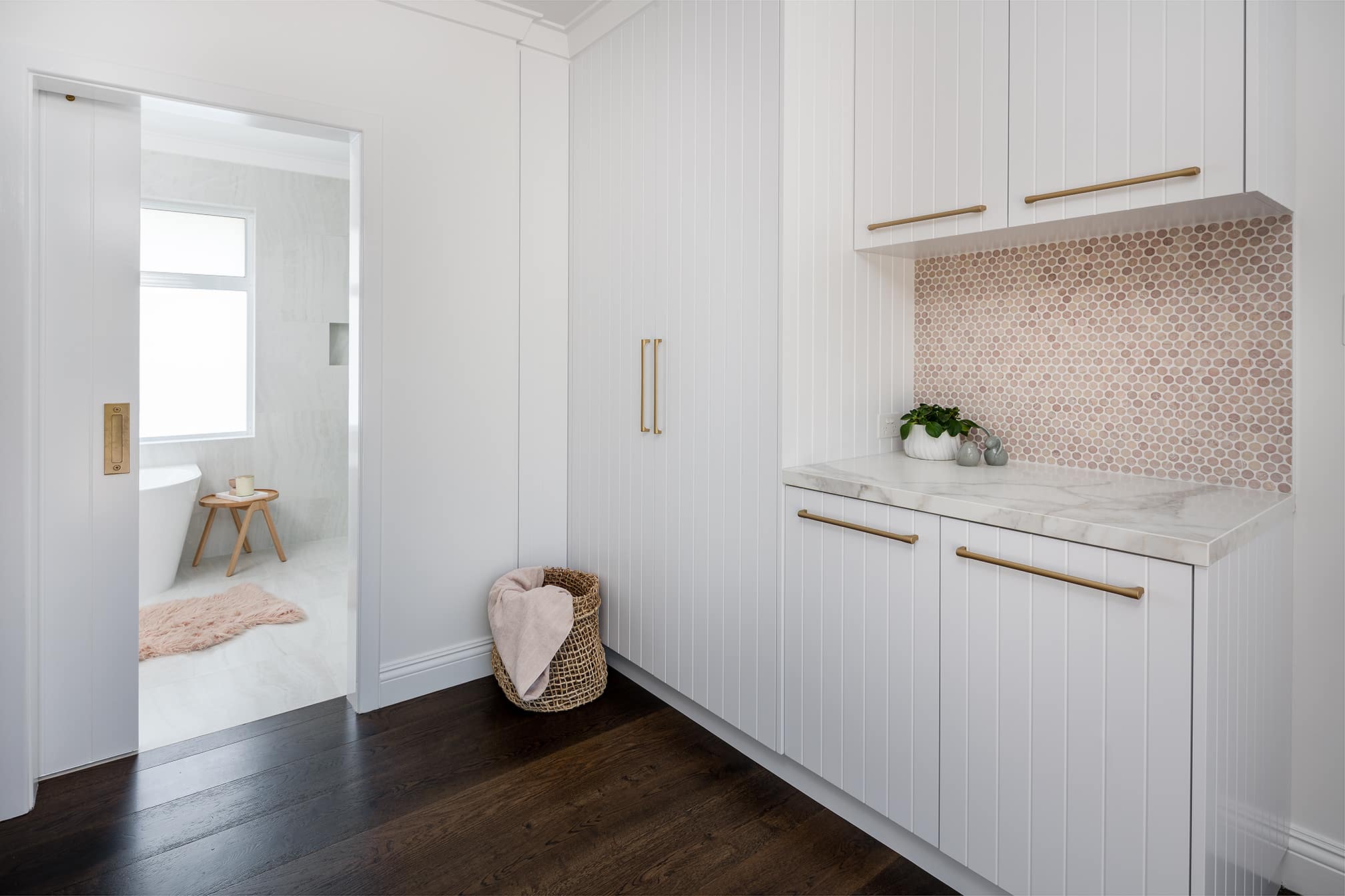 A photo of a laundry area with a wooden floor.