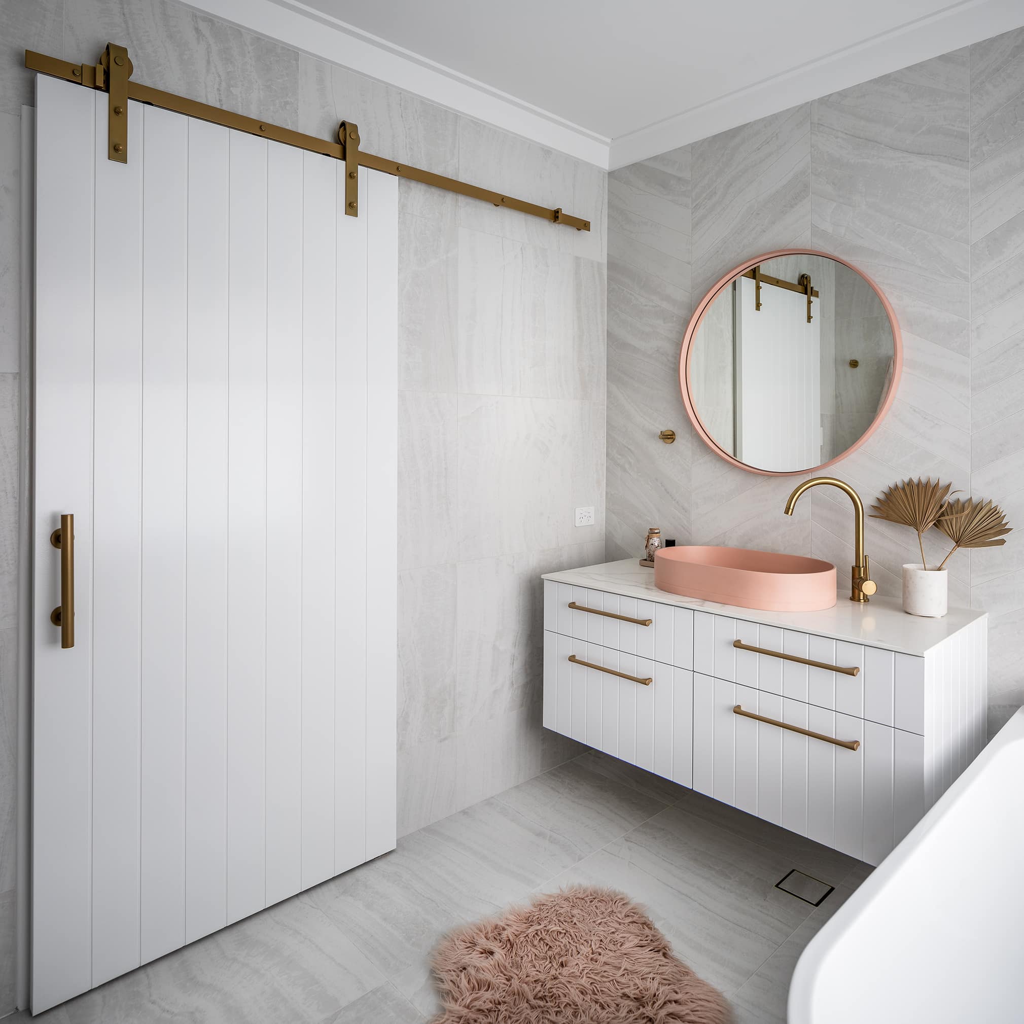 A photo of a small bathroom area, with a single sink, a rug and a bath tub next to it.