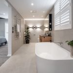 A photo of an ensuite bathroom, with a large tub, toilet and sink.