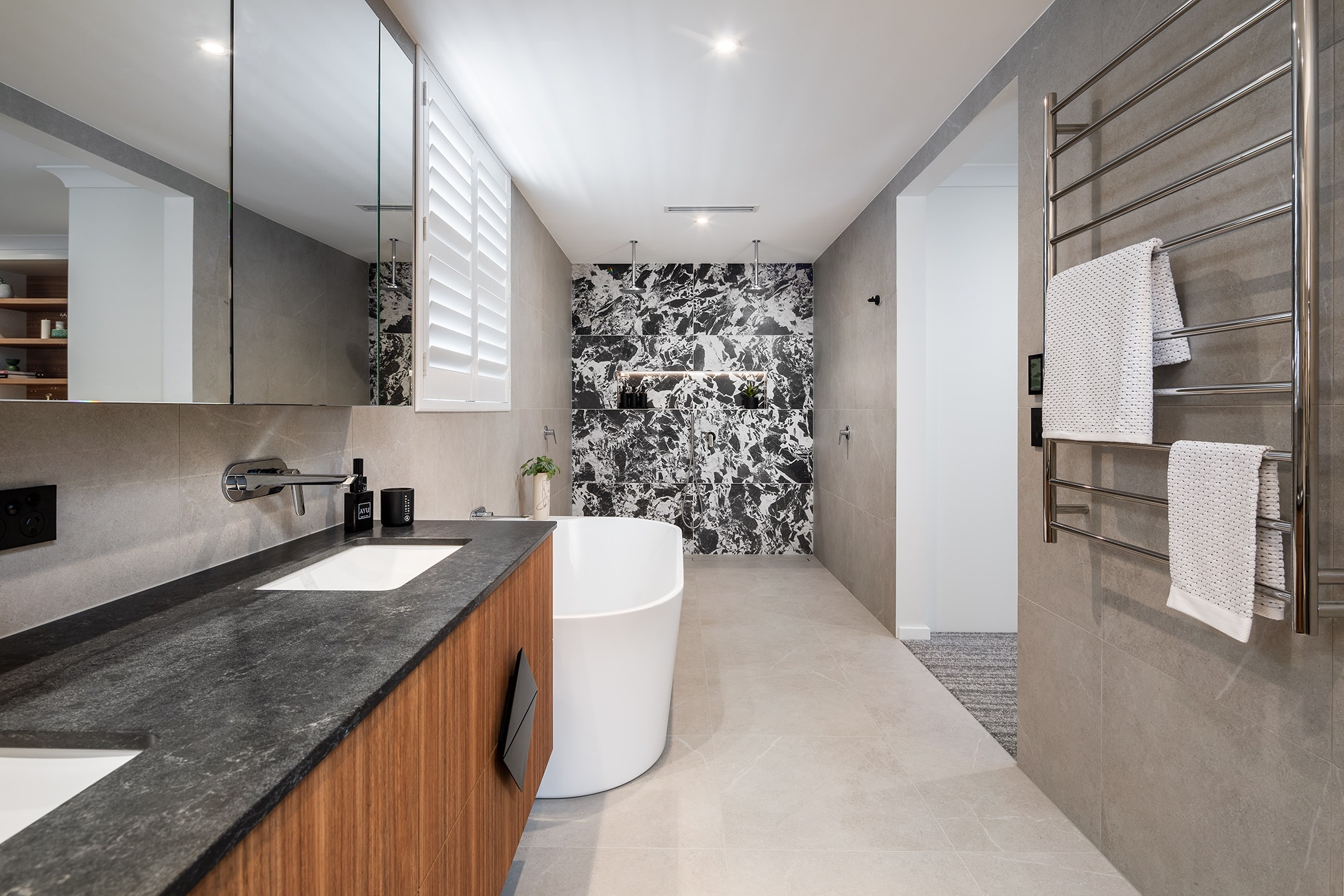 A photo of the ensuite bathroom, with a large bathtub and dual shower room in the back.