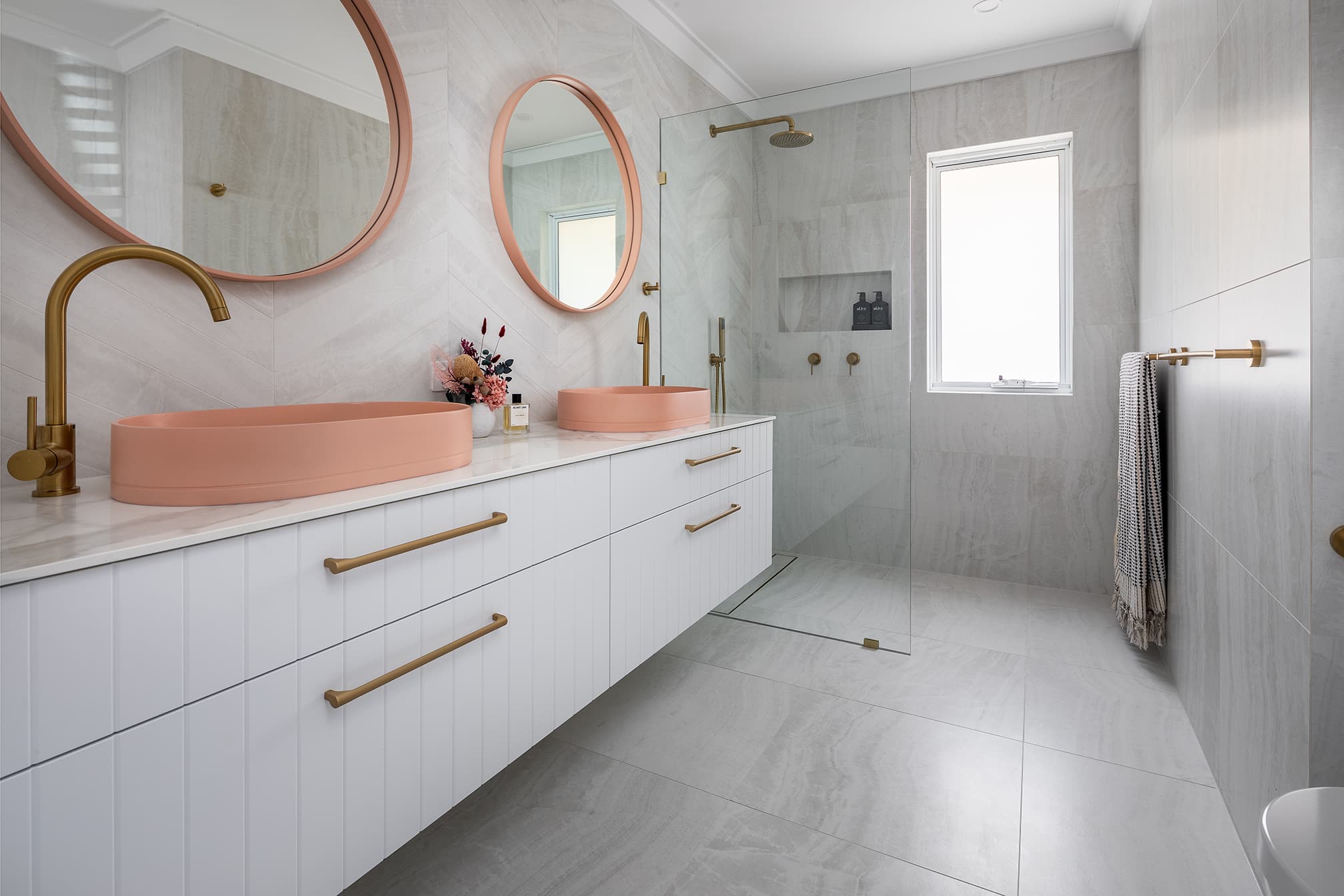 A photo of a bathroom area, with a shower and dual vanity sink.