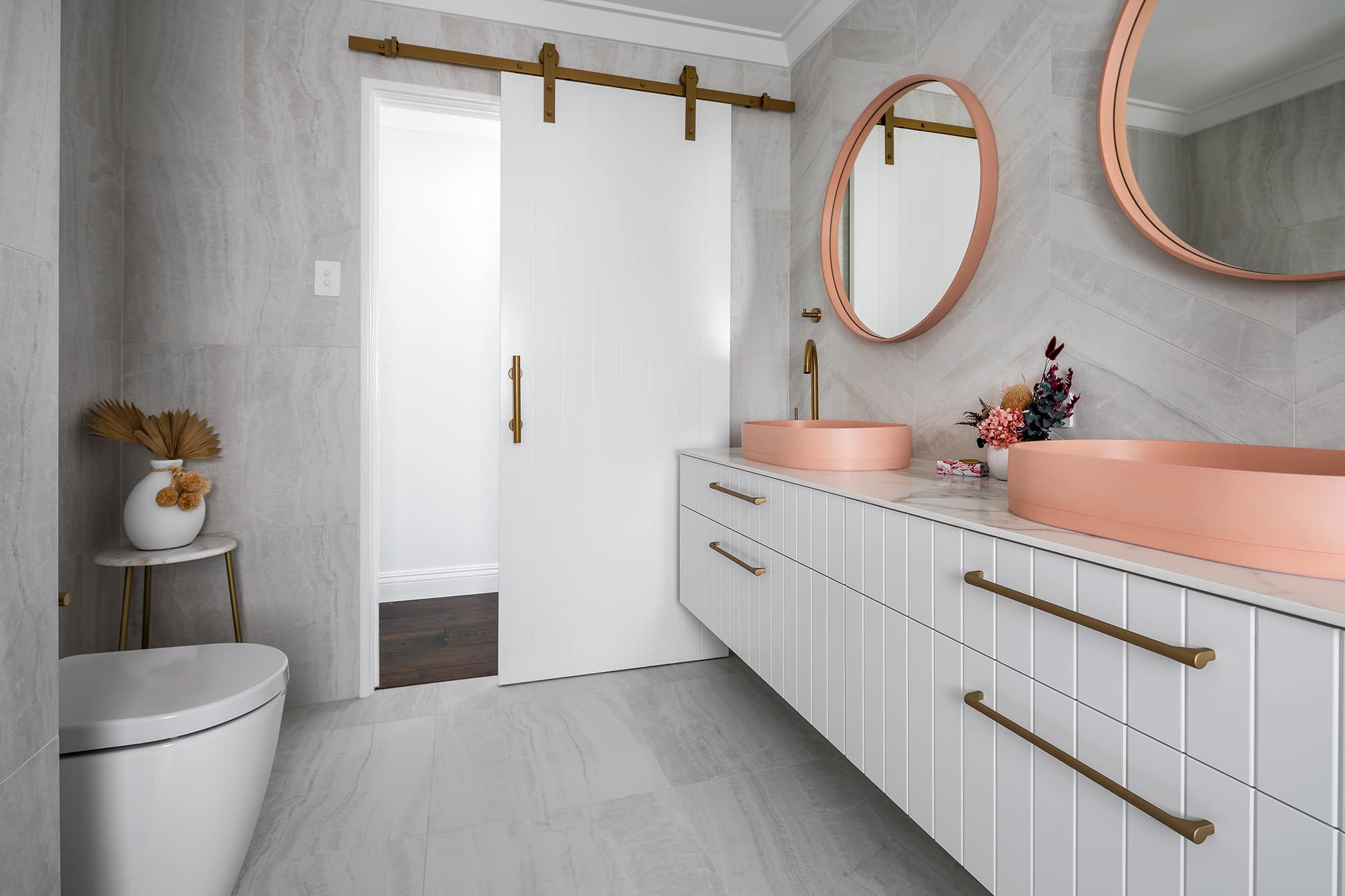 A photo of a bathroom area, with a toilet and double vanity.