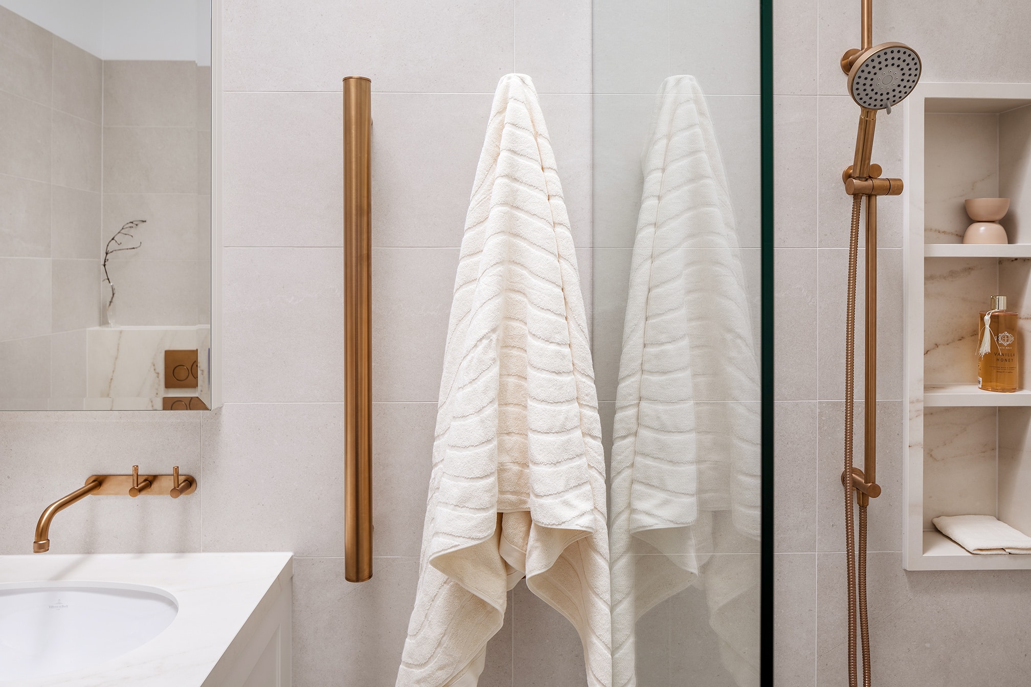 A photo of a towel, hanging up next to a shower.