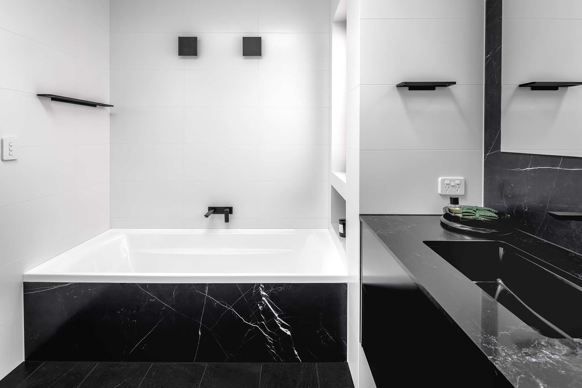 A photo of a bath tub and sink in the corner.