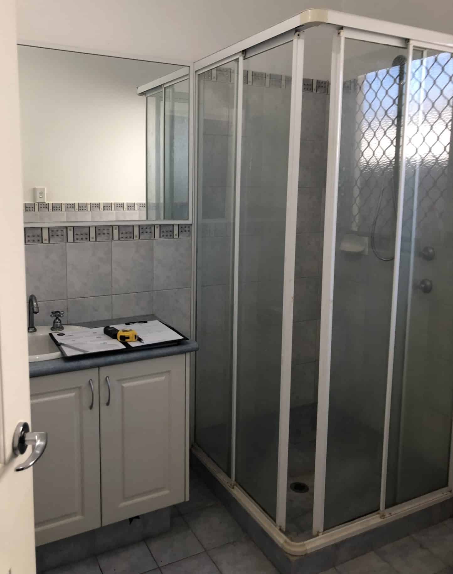 A photo of a shower area, with a sink next to it.