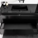 A photo of a black vanity, with a large sink.