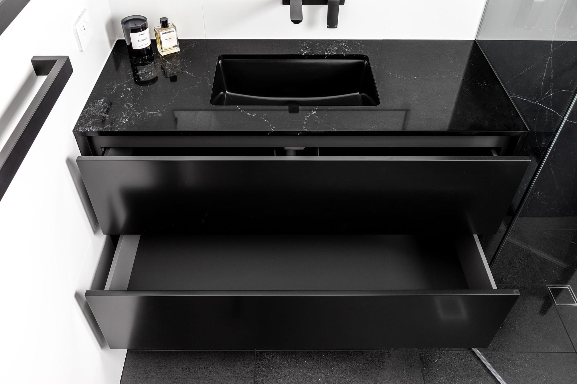 A photo of a black vanity, with a large sink.