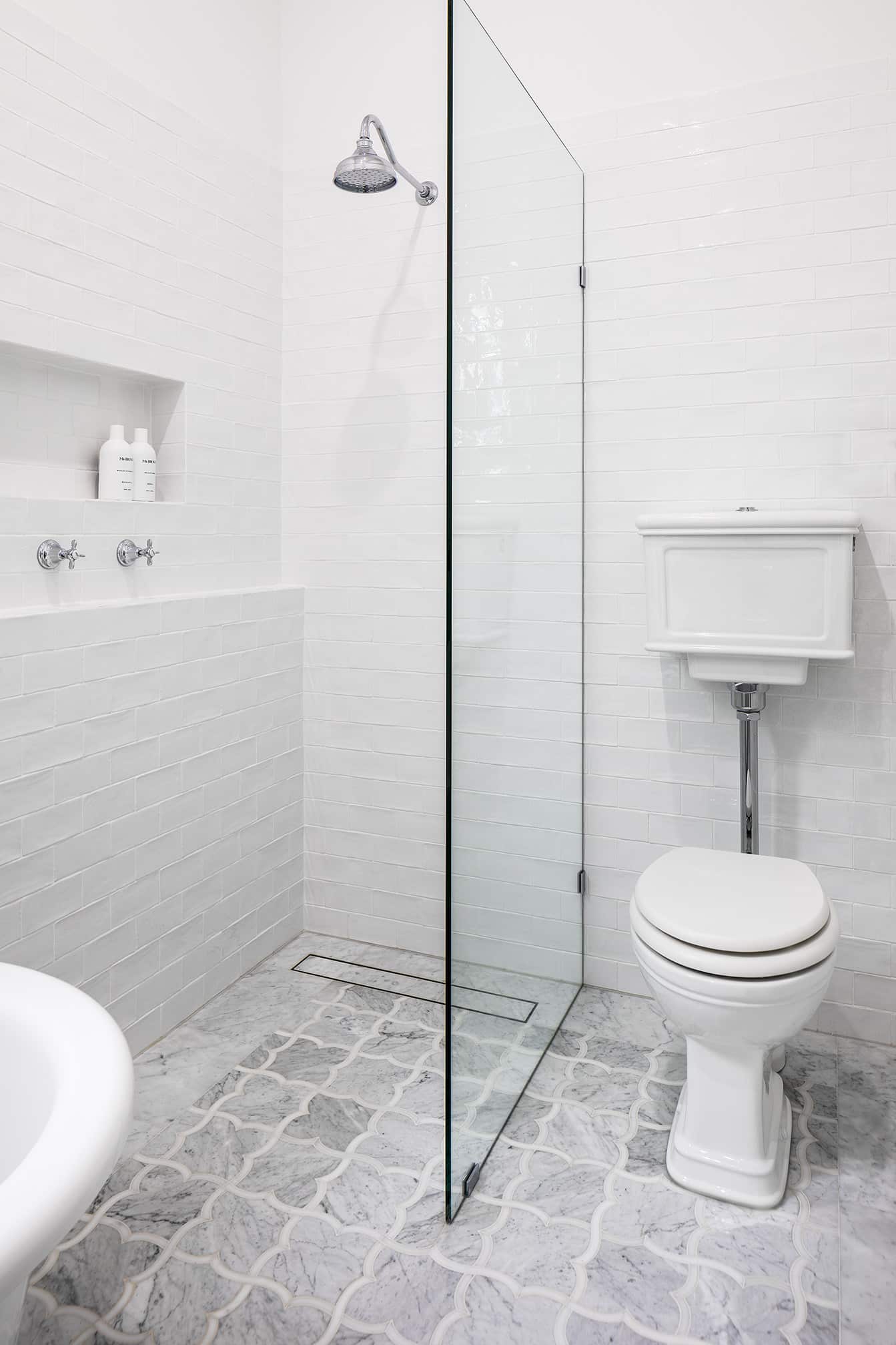 A photo of a shower area, next to a toilet.