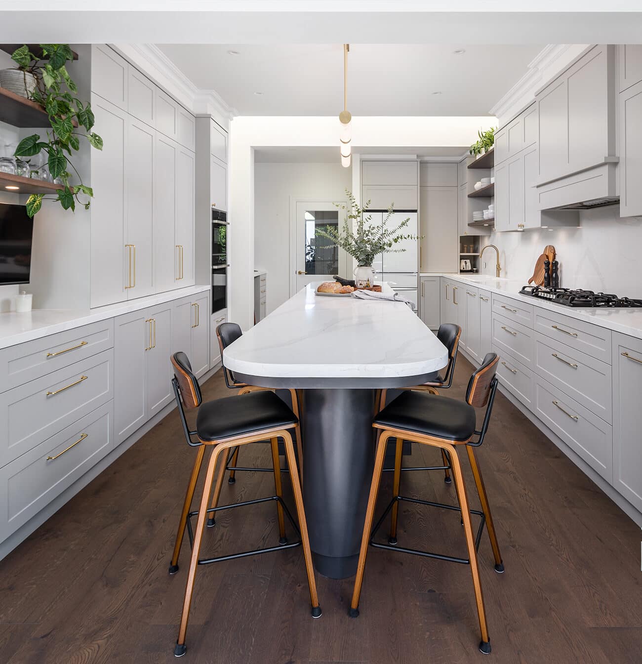 A photo of a kitchen area, with a island in the middle and stove on the right side.