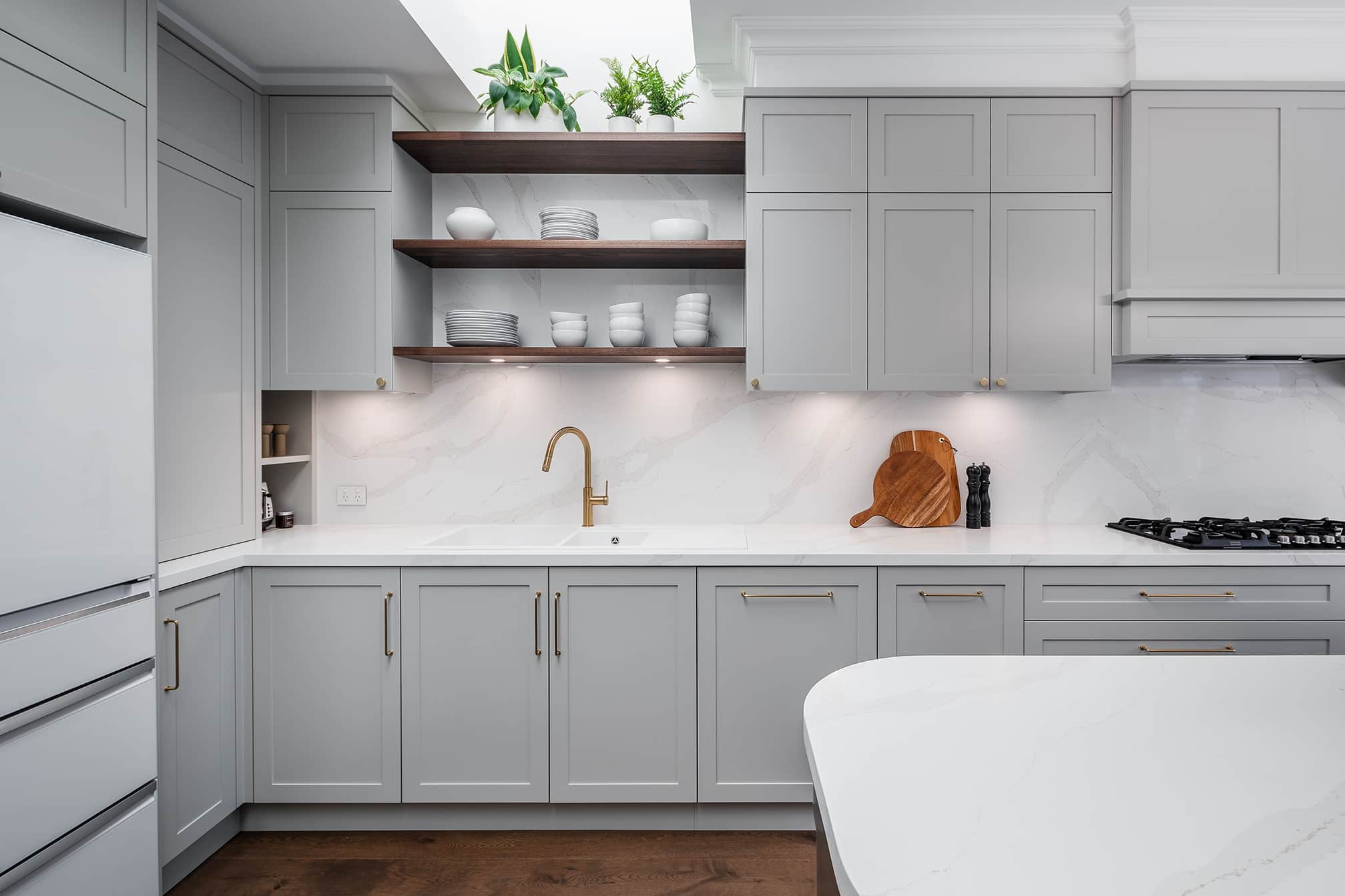 A photo of a kitchen area, with a sink and cupboards.