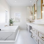 A photo of a bathroom area, with a bath tub and sink.