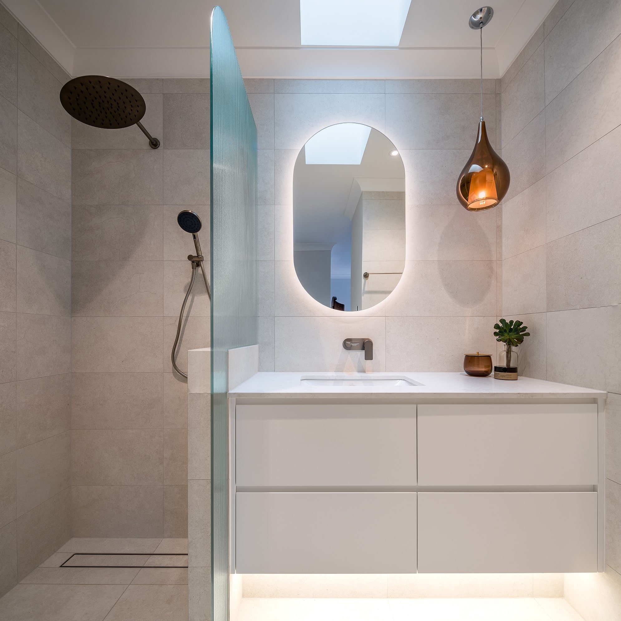 A photo of a freshly renovated bathroom area, with a shower and sink.