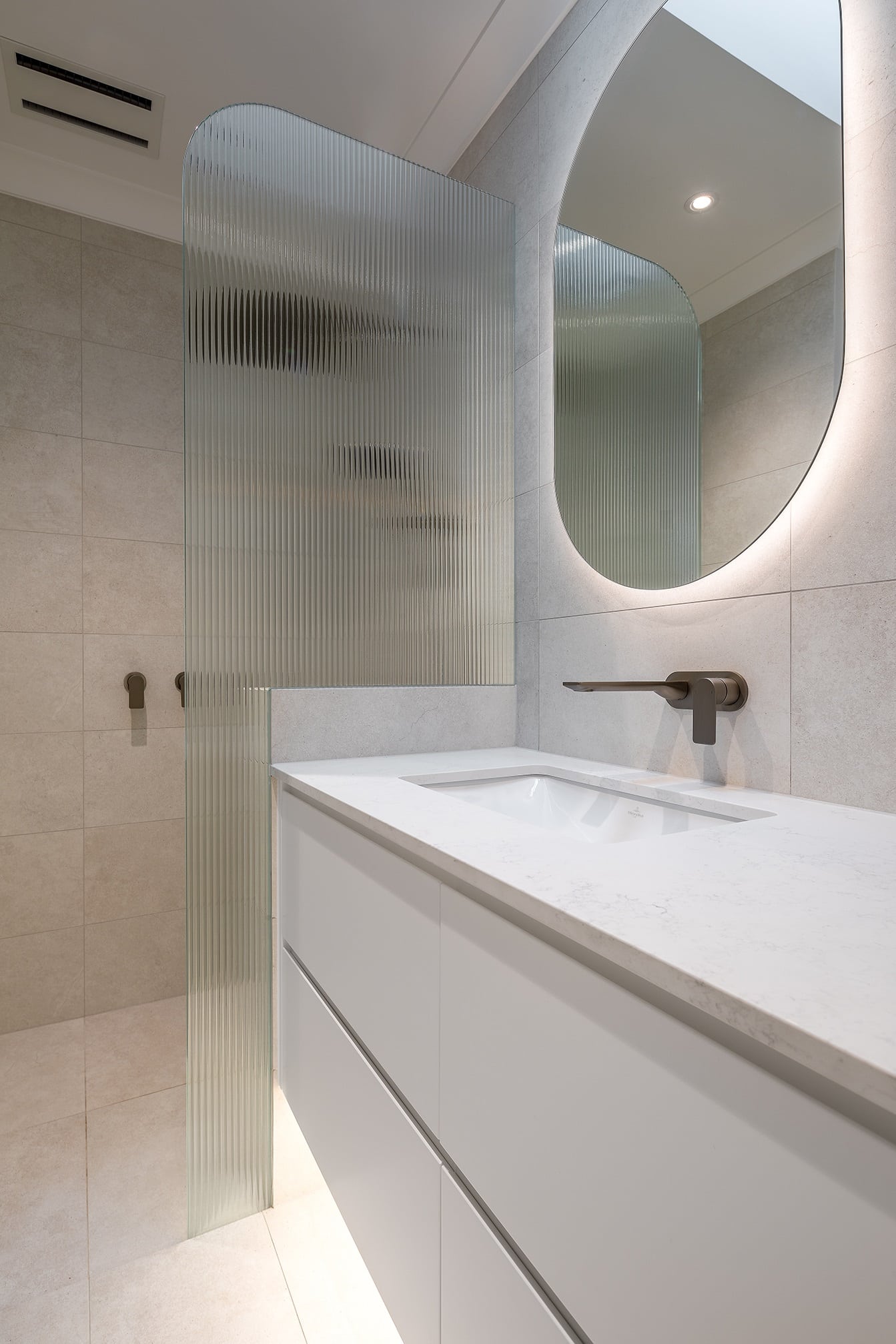 A photo of a shower area and a sink in the foreground.