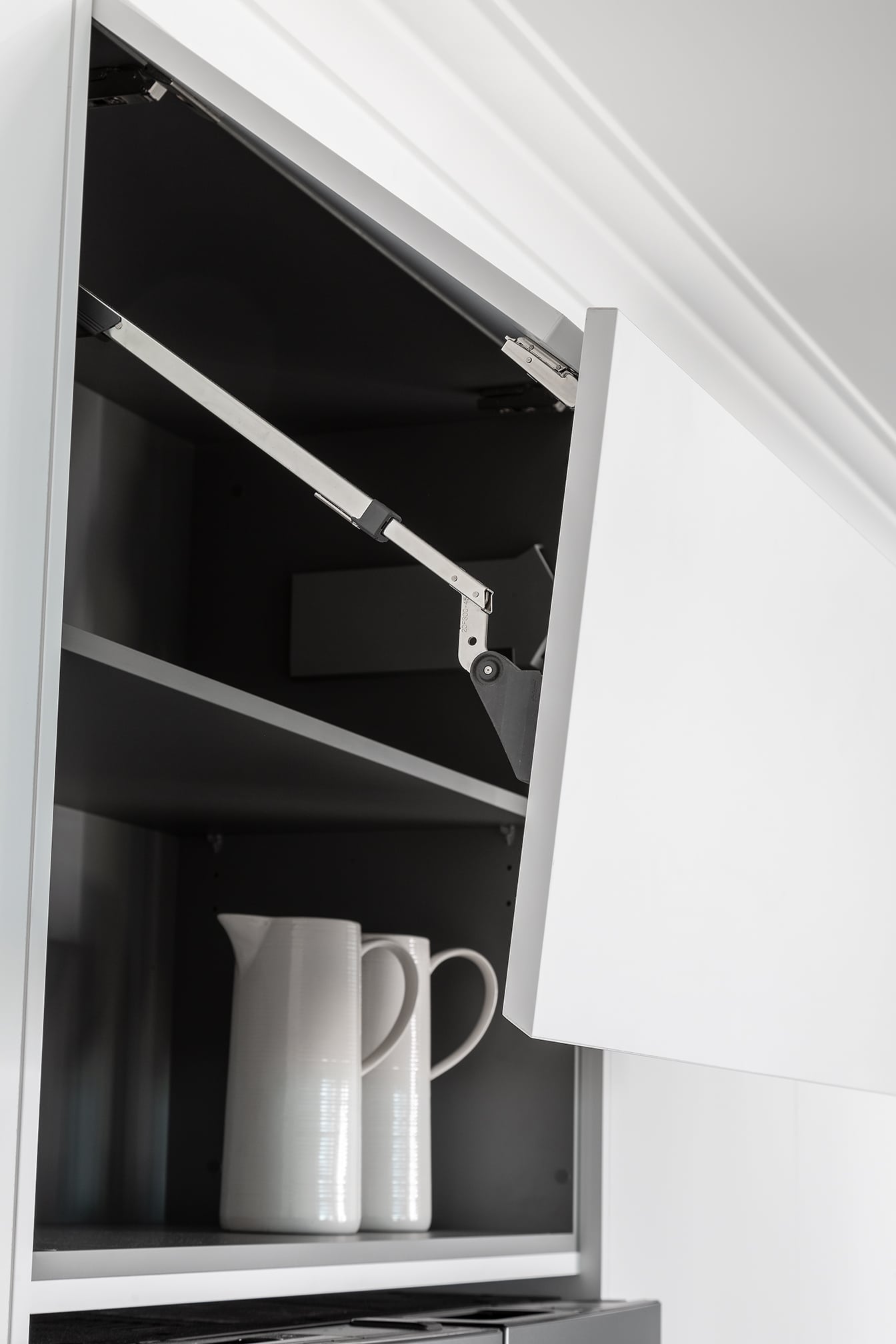 A photo of a cabinet, opened, with two jugs inside of it.