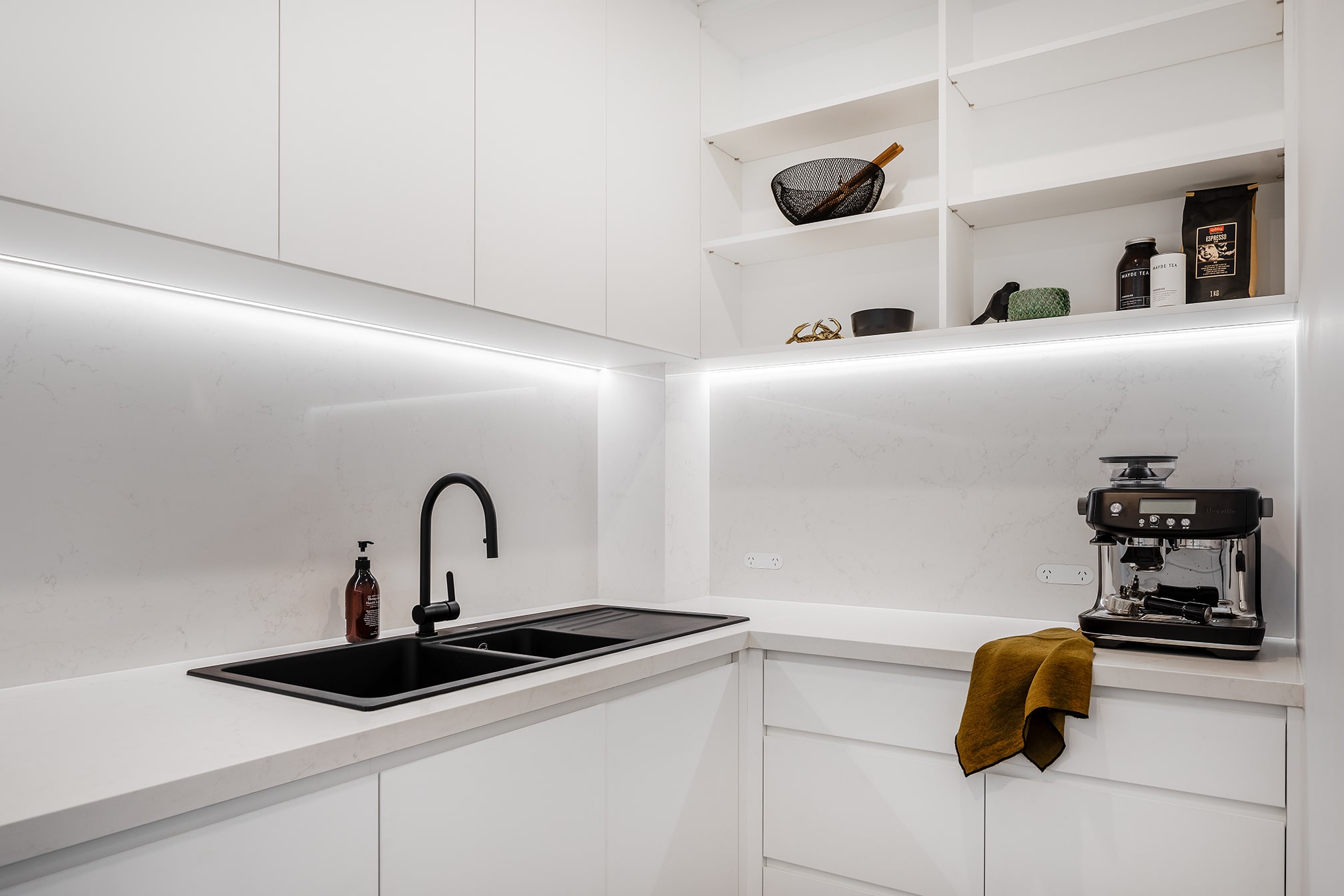 A photo of the butler's pantry. There is a sink and coffee machine.