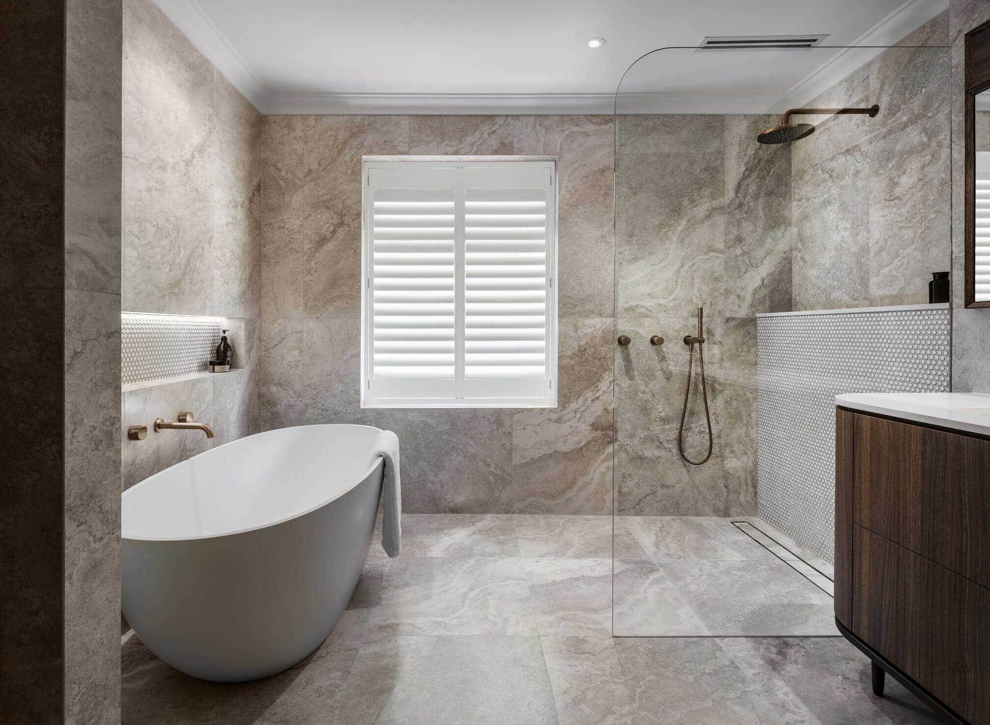 A photo of a newly renovated bathroom, with a large bathtub, shower and sink.